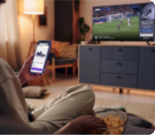 pessoa com smartphone assistindo TV